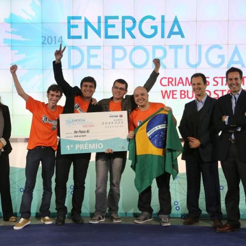 7 pessoas da EDP comemorando um prêmio, uma delas segurando a bandeira do Brasil
