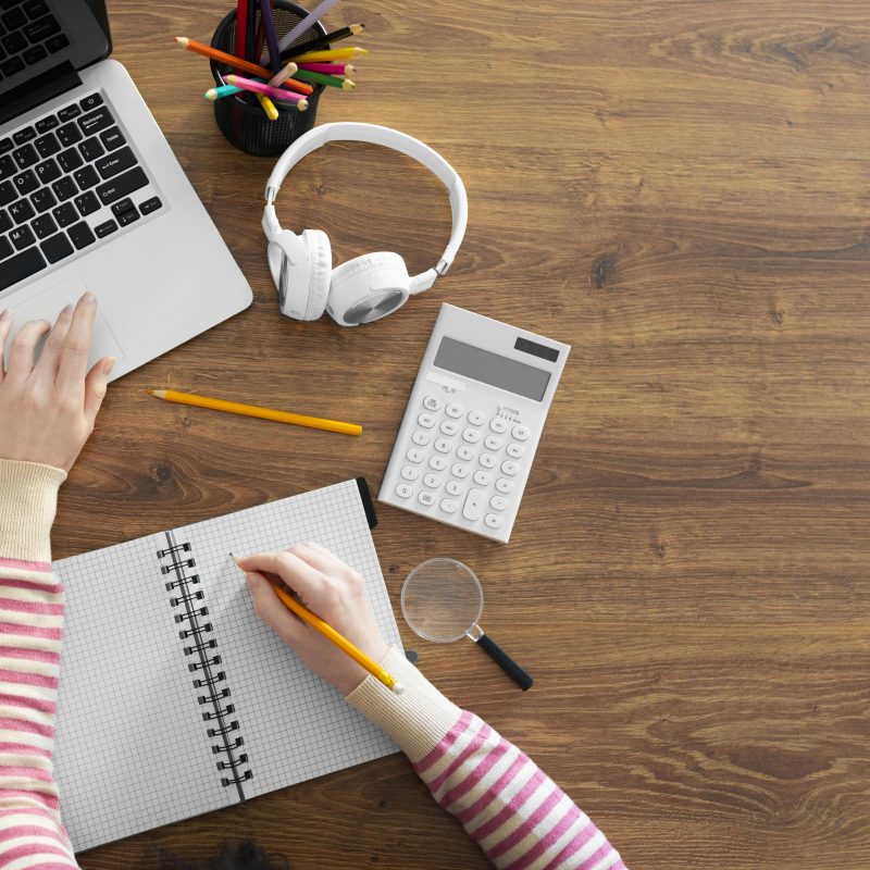 Mesa de trabalho com notebook, calculadora, fone e caderno de anotações. Aprendizagem ativa